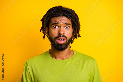 Portrait of disappointed afraid dark skin guy look in camera feel worried isolated over vibrant yellow color background © deagreez