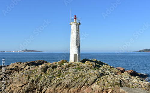 Old white lighthouse with blue sky at famous Rias Baixas Region. Muxia, Coruña, Galicia, Spain.