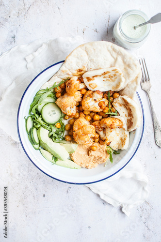 Vegetarian shawarma made with chickpeas and cauliflower, served with naan bread and fried halloumi cheese photo