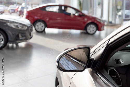 New cars at dealer showroom. Themed blur background with bokeh effect. Car auto dealership. © tikhomirovsergey