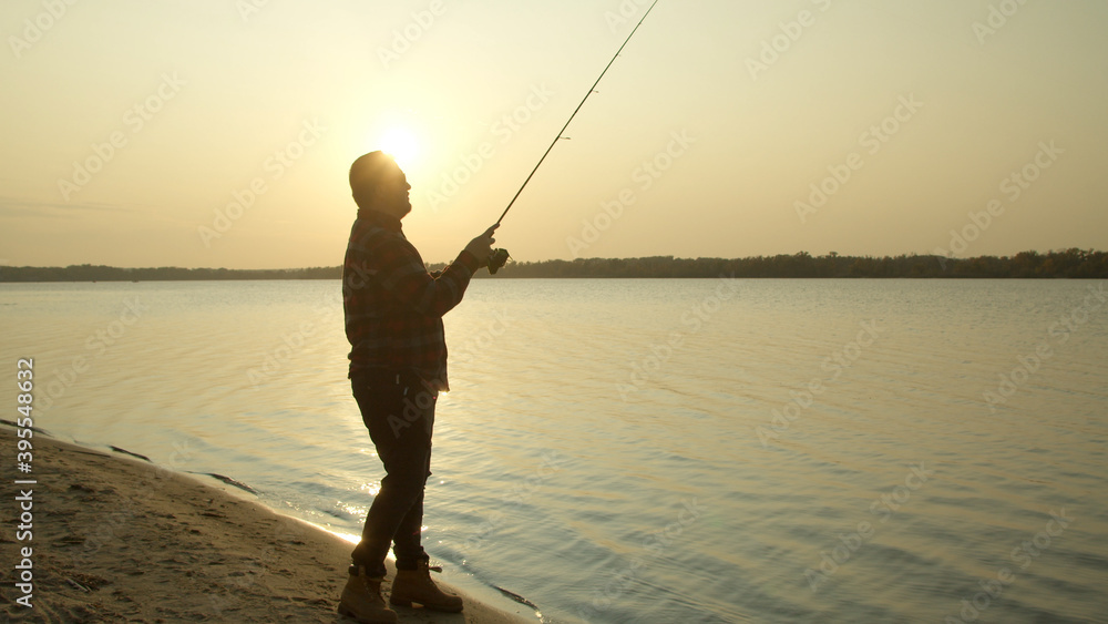 Male angler taking selfie with fish near water