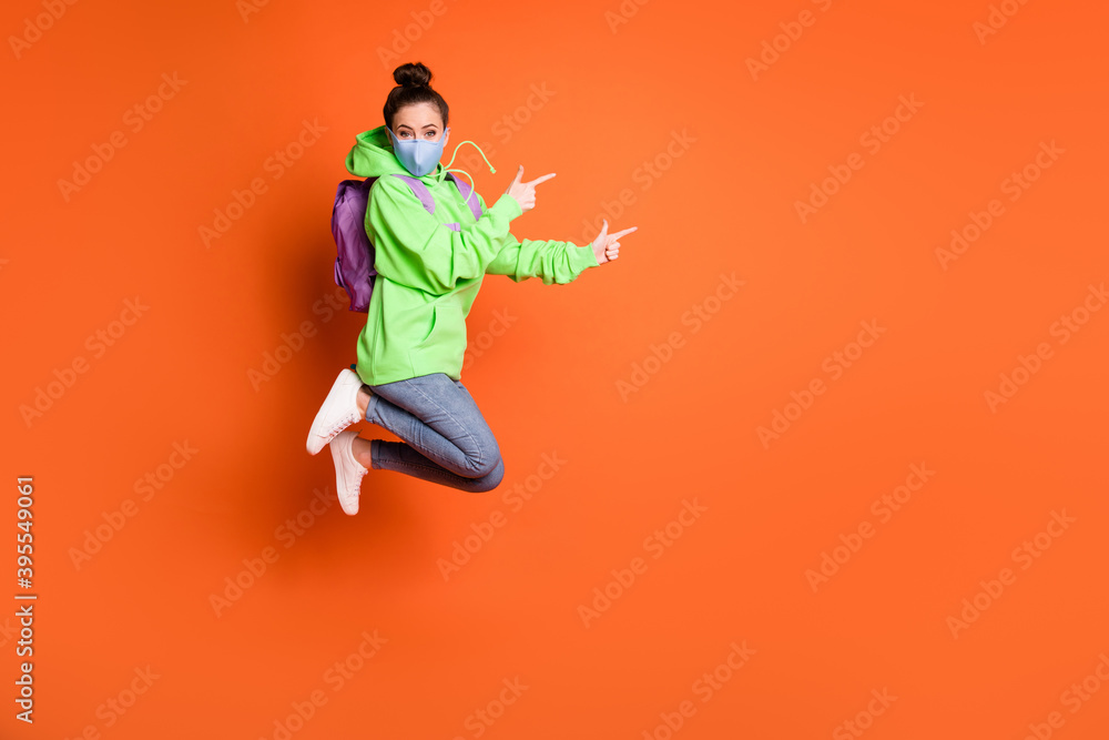 Full size portrait of model jump indicate empty space wear sweater bag jeans shoes isolated on orange color background