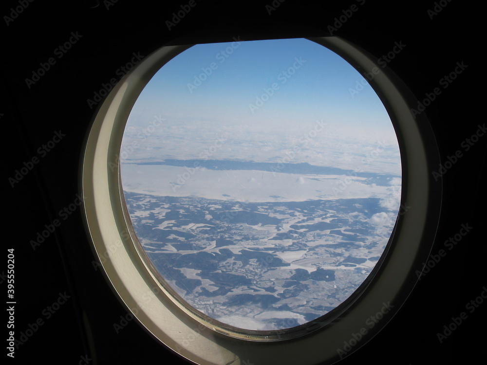 The ground in the plane's window is visible.