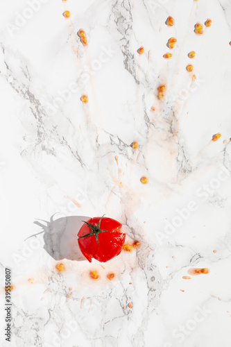 A splattered tomato on a marble surface photo