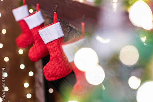 Christmas red socks for gifts on the fireplace in bokeh lights.