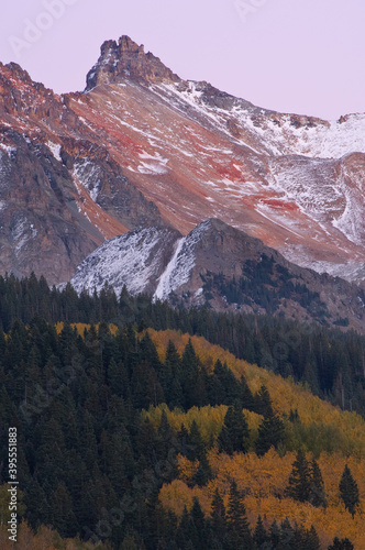 Autumn landscape at twilight, San Juan Mountains flocked with snow and with conifers and aspens, Colorado, USA