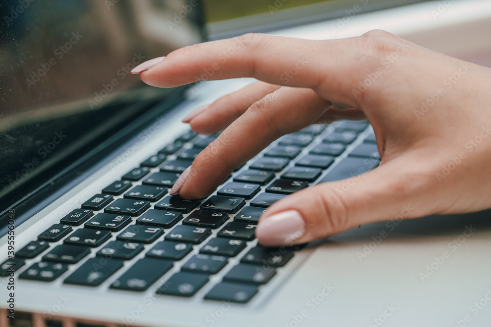 Hands writing ond a keyboard of a laptop or a notebook in Home Office