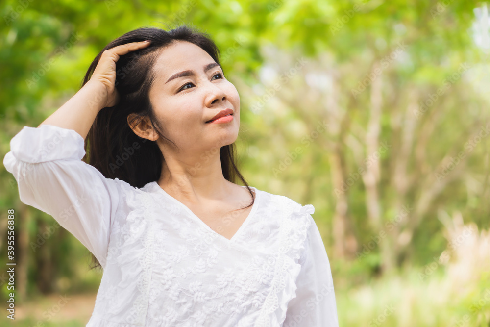 portrait  of beautiful Asian woman smiling outdoors with nature background