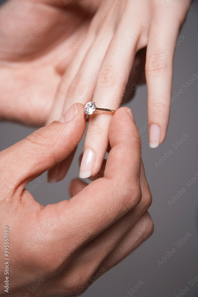 Man Placing Engagement Ring In Woman's Finger