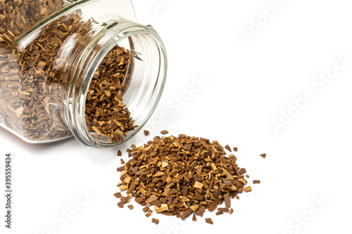 Pile of natural sublimated coffee  scattered from a glass jar, isolated on white background.
