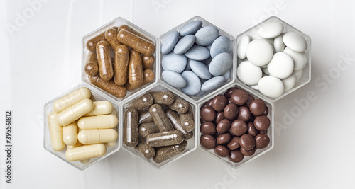 Various medical capsules and tablets in hexagonal jars