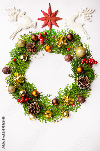 Winter and christmas wreath with gold christmas toys on white background.