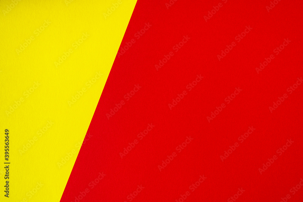 Beautiful background of two unequal parts yellow and red. Sheets of blank yellow and red paper with fine texture separated by a sloping border. Beautiful background of two unequal parts yellow and red. Sheets of blank yellow and red paper with fine texture separated by a sloping border.