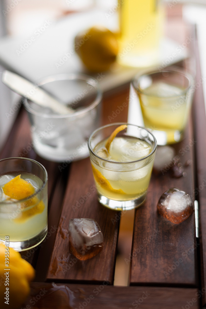 Limoncello with ice cubes and fresh lemon peel Limoncello with ice cubes and fresh lemon peel