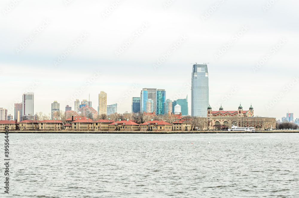 Ellis Island Immigrant Station and Jersey City Skyline in Background. New York City, USA