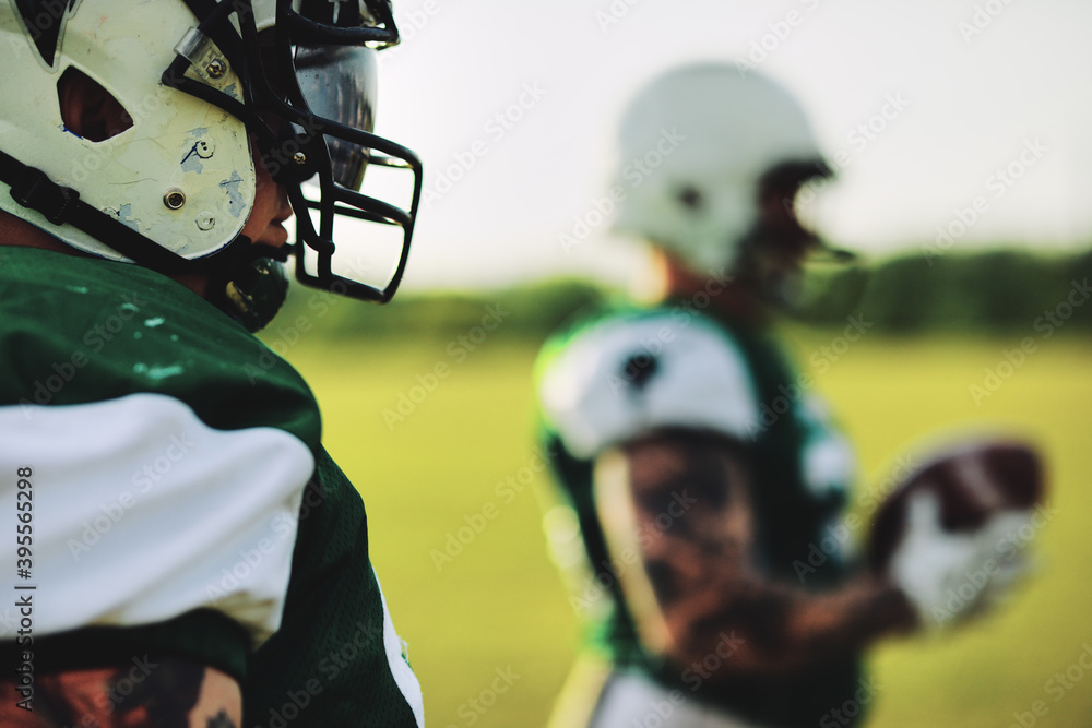 Fototapeta premium American football player standing with teammates before a game