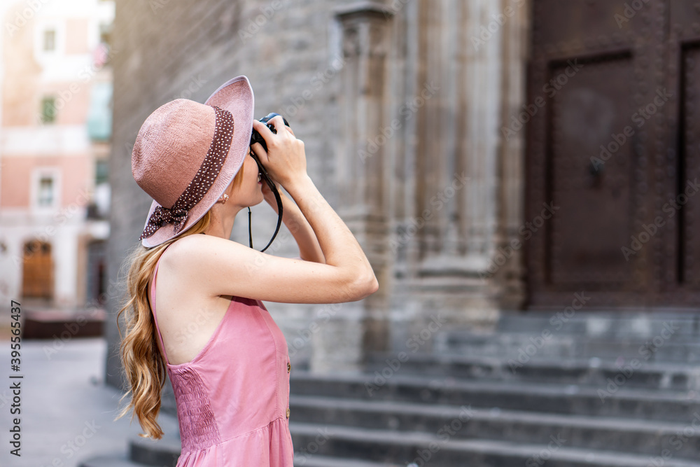 Female professional photographer taking pictures of a church in Spain. Architecture and travel photography.  Woman solo traveler in Barcelona.