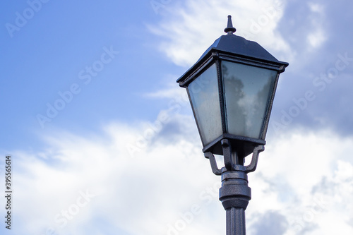 old street light against the sky, the sky is reflected by the glass of a lantern © Olha Trotsenko