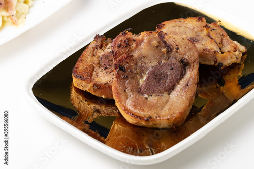 Slika na platnu Closeup of deliciously grilled pork meat on a plate isolated on a white backgrou