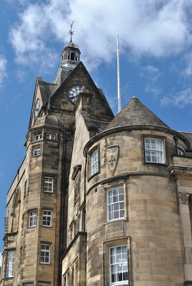 Old Stone Public Building & Clock Tower seen from Below against Blue Sky