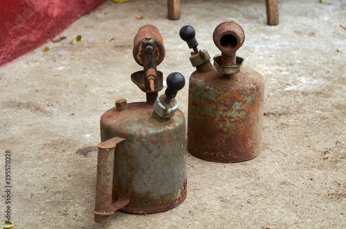 Photo of two gasoline blowtorchs on concrete