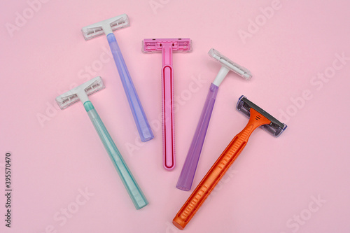 Set of multi-colored disposable shaving machines for women on a pink background. Close-up