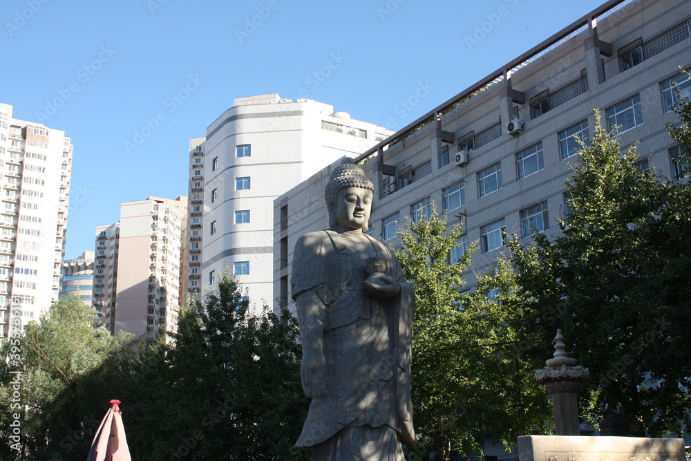 Buddhist Statue at an Antique Market in China contrasting with the modern building behind