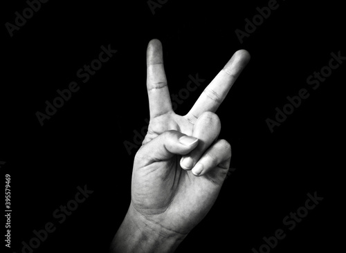 sign of Peace of a Woman hand in a black background