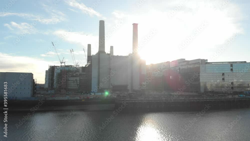 Low Circling drone shot of Battersea power station sunset flares