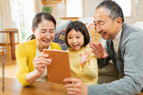 タブレット学習をする孫を見守る祖父母