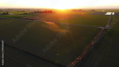 Sunset view of Central Valley California agriculture farming land with almond trees during dusk