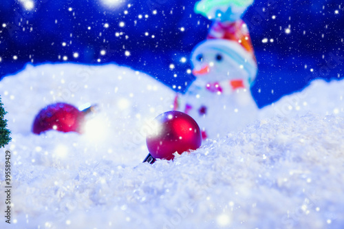Christmas background with Christmas balls on snow over fir-tree, night sky and moon. Shallow depth of field. Christmas background. Fairy tale. Artificial magic dreamy world.