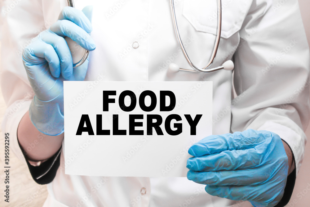 The doctor's blue - gloved hands show the word FOOD ALLERGY - . a gloved hand on a white background. Medical concept. the medicine