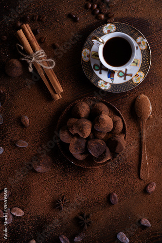 healthy delicious chocolate truffles around ingridients with natural cocoa beans, powder, cacao butter, cane sugar and cup of coffee. healthy sweets concept. flat lay