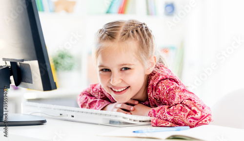 Smiling little girl at computer desk