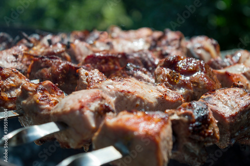 Fried shish kebab on a skewer close-up. Pork barbecue. Selective focus.