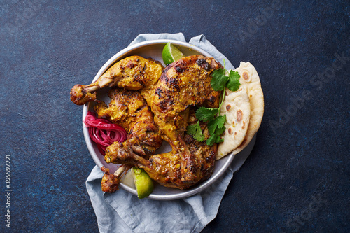 Marinated tandoori chicken with naan, limes and coriander (India)
