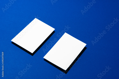 Two stacks of blank businesscards on blue background photo