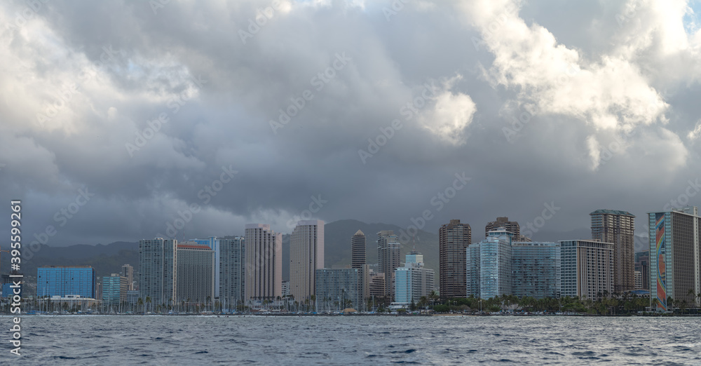 Offshore view of a cityscape with rain showers.