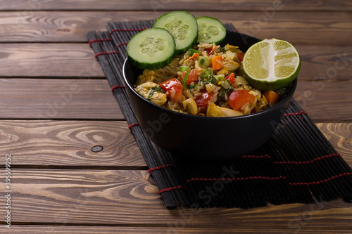 Asian khao pad kung fried rice with vegetables, meat, egg, fresh cucumbers and tomatoes