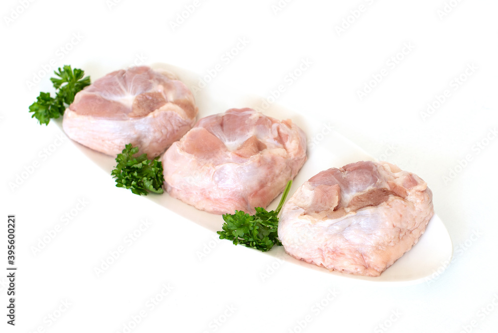 Raw turkey chicken tail on a plate on a white background. Isolate. Copy space. Raw turkey chicken tail on a plate on a white background. Isolate. Copy space.