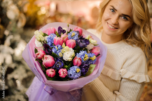 charming bouquet of colorful spring fresh flowers h in hands of blonde woman.