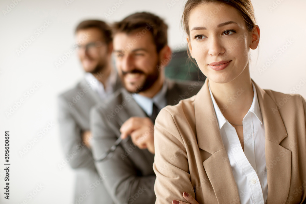 Smiling young business woman standing with group of corporate colleagues in a row together Smiling young business woman standing with group of corporate colleagues in a row together
