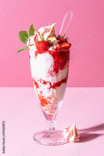 Strawberry sundae with ice cream, whipped cream, crushed meringue, strawberry sauce and mint photo