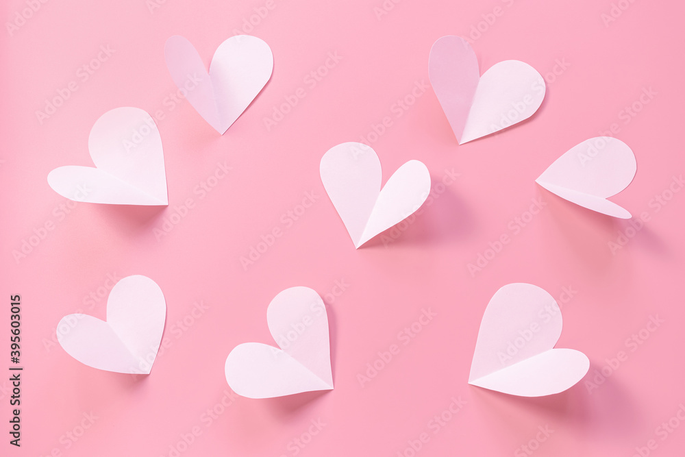 Pink paper hearts on a pink background. Concept of romance, love, valentine's day. Minimalism, copy space, paper art.