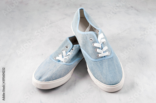 pair blue fabric stylish sneakers with laces on grey textured background
