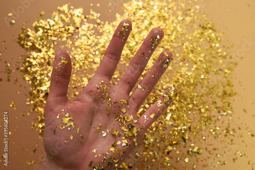 Golden glitter on woman hand
