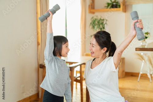 室内で運動する祖母と孫