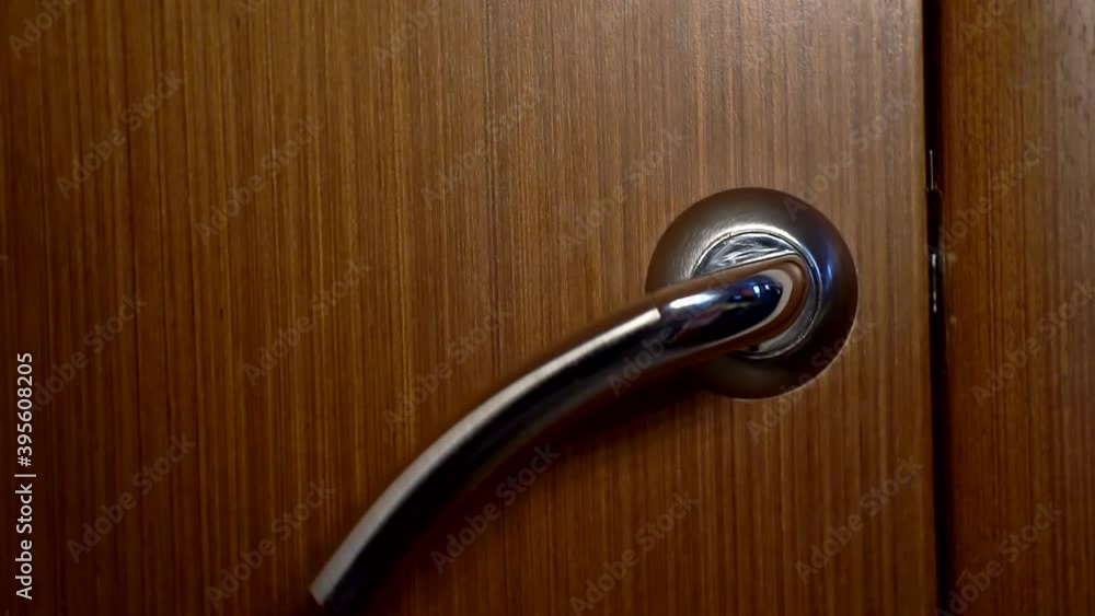 The door handle twitches, someone is trying to get in house. Closeup The door handle twitches, someone is trying to get in house. Closeup
