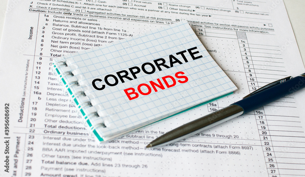Notepad with text Corporate Bonds lying on financial tables with a pen Notepad with text Corporate Bonds lying on financial tables with a pen